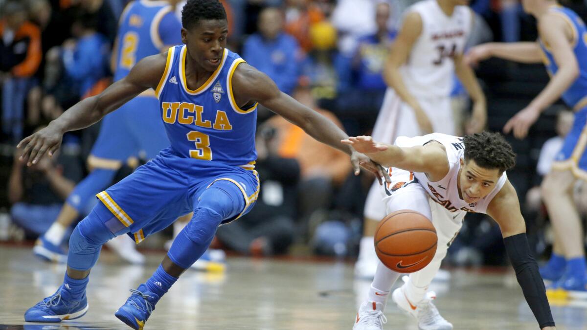 UCLA guard Aaron Holiday and Oregon State guard JaQuori McLaughlin chase after a loose ball during the first half Friday night.