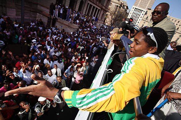 South African runner Caster Semenya acknowledges adoring crowds upon her return to her homeland after winning a gold medal in the women's 800-meter race at the world track championships in Berlin last week. The stunning victory was clouded when some opponents accused Semenya of being a man, and the sport's governing body ordered the athlete to undergo a battery of gender tests. Results may not be known for several months.