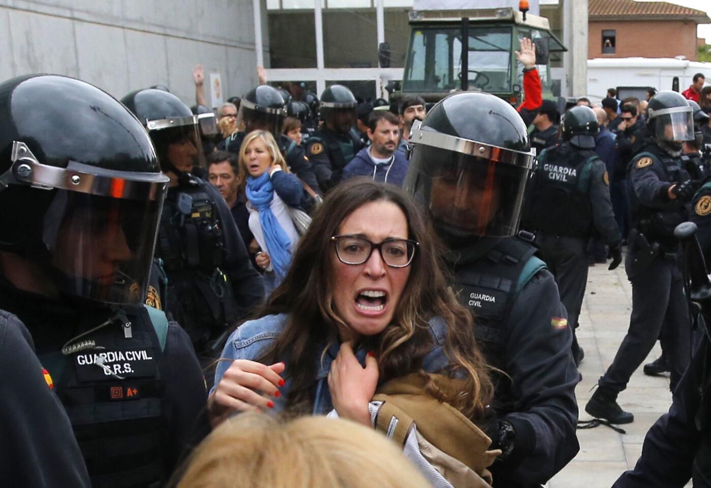 People clash with members of the Spanish Civil Guard on Sunday outside a polling station in Sant Julia de Ramis, where the Catalan president was supposed to vote in the referendum on Catalan independence.