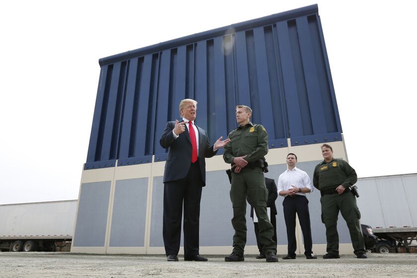 President Donald Trump tours the border wall prototypes near the Otay Mesa Port of Entry in San Diego County on March 13, 2018. At right is Rodney Scott, Chief Patrol Agent of the San Diego Sector of the Border Patrol. (Photo by K.C. Alfred/ San Diego Union -Tribune)