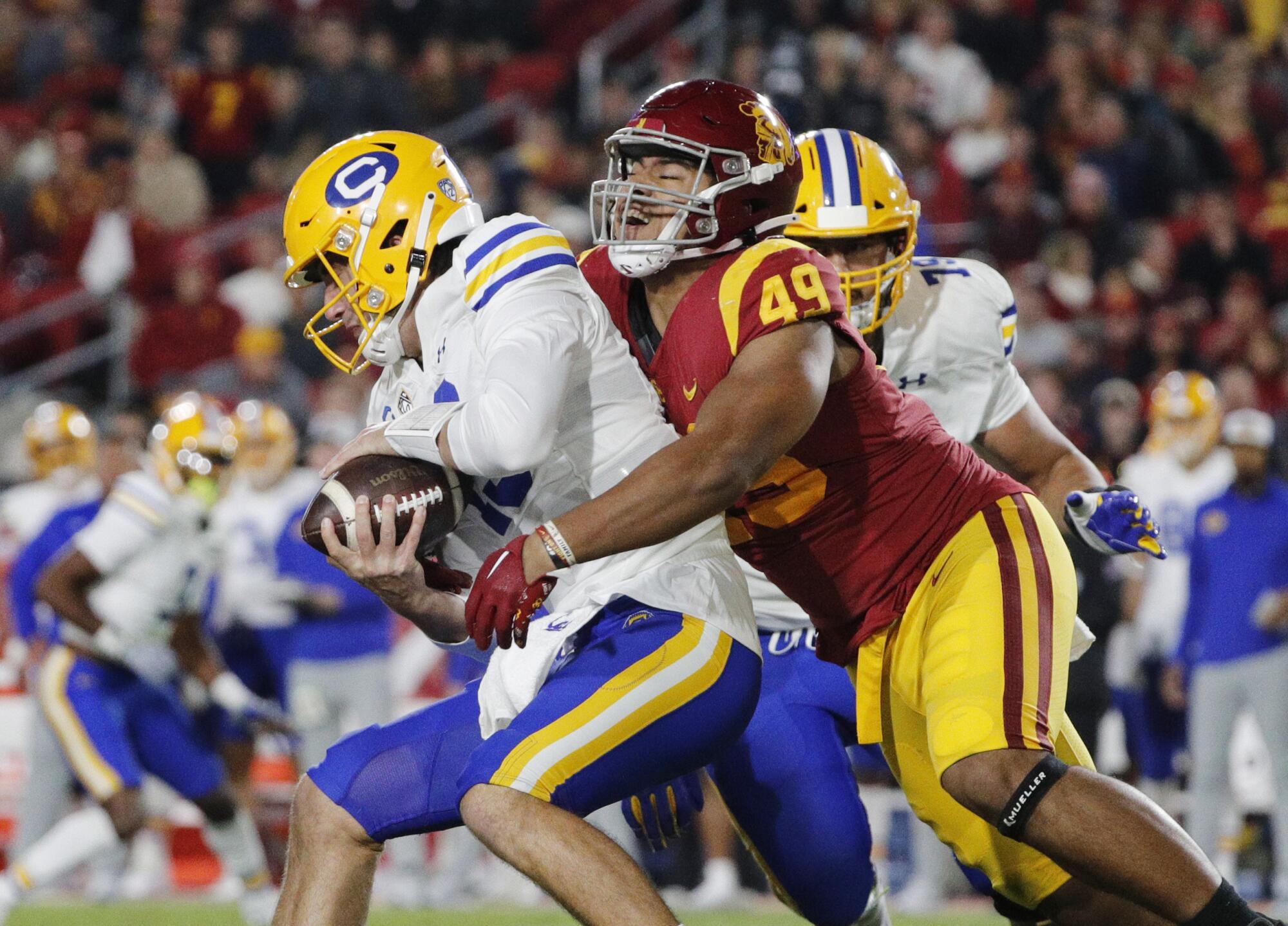 USC defensive lineman Tuli Tuipulotu sacks California quarterback Jack Plummer during the first half.