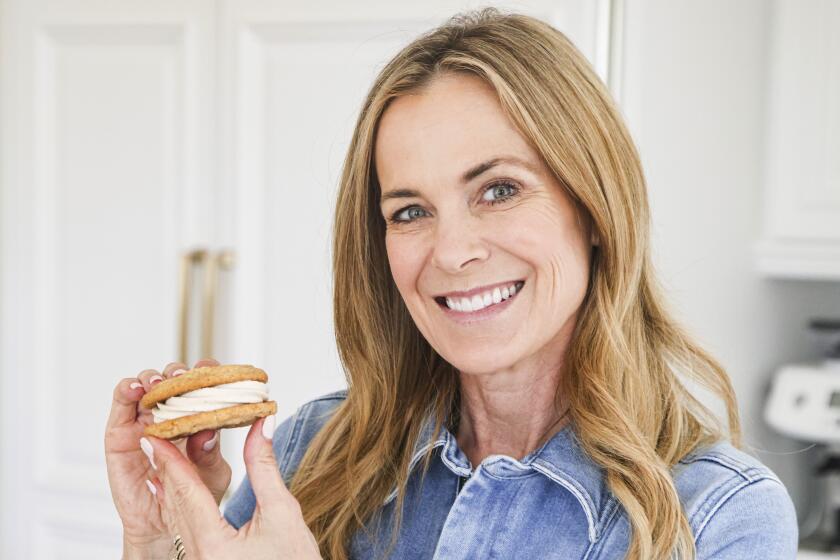 A cookbook author holds up an example of one of her stuffed sandwich cookies.