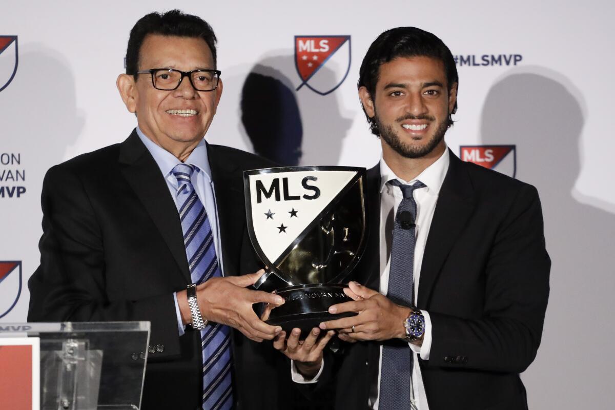 Former Dodgers pitcher Fernando Valenzuela poses with LAFC's Carlos Vela with Major League Soccer's Most Valuable Player trophy. 