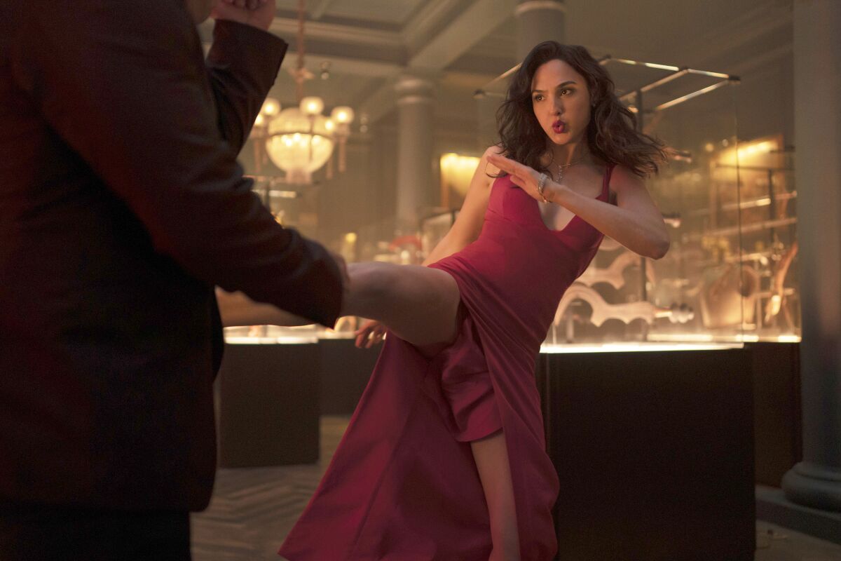 Gal Gadot kicks a person in a scene from “Red Notice.”