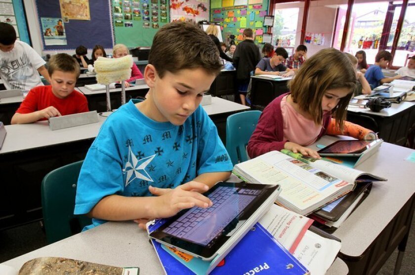 Encinitas Union School District students use iPads at El Camino Creek Elementary. A new contract that has drawn parent scrutiny proposes to simplify iPad logins, either through a keyed-in password or biometric facial recognition software.