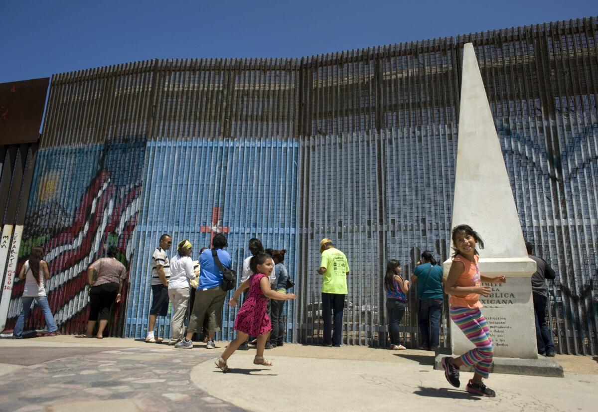 Familias se reúnen junto a una valla metálica en la frontera hoy, domingo 21 de junio de 2015, en el Parque de la Amistad en Tijuana (México). El parque que se ubica en la frontera con EE.UU. y que es escenario habitual de encuentros entre seres queridos separados por problemas migratorios, fue hoy un punto de reunión por el Día del Padre entre familias cruzadas por una orden de deportación.