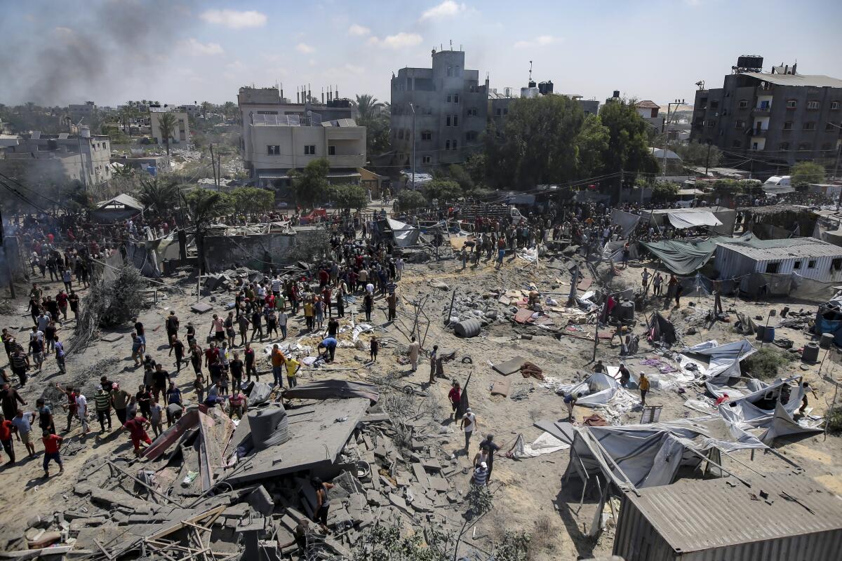Palestinians inspect the damage at a site hit by an Israeli bombardment on Khan Yunis, southern Gaza Strip.