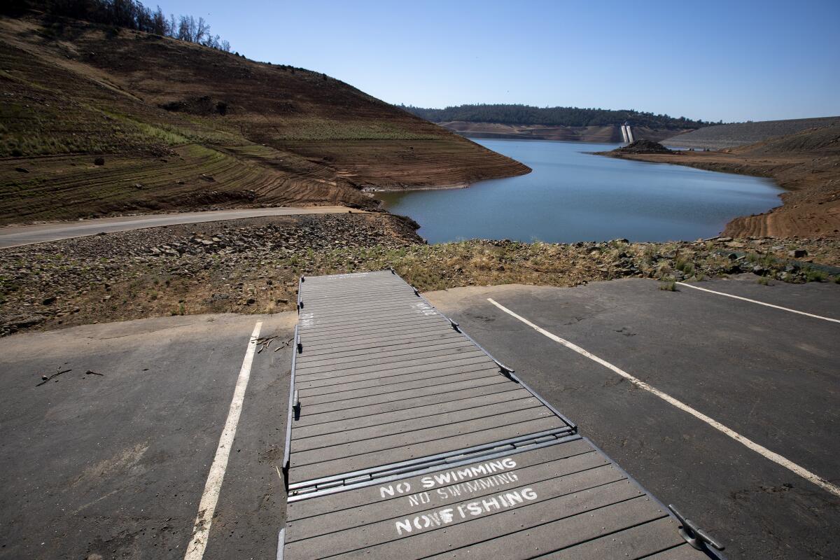 A boat dock is left high and dry on the shoreline at Lake Oroville on June 29, 2021.