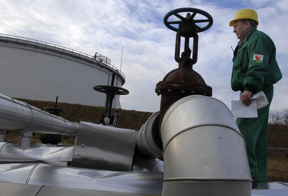 FILE - Istvan Szekeres, engineer of the Hungarian Oil and Gas Company (MOL) checks the receiving area of the Druzhba oil pipeline in the country's largest oil refinery in Szazhalombata, south of Budapest, Hungary, Jan. 9, 2007. Several countries in Europe dependent on Russian energy suffered another blow with confirmation Tuesday, Aug. 9, 2022 that oil shipments have stopped through a critical pipeline. Russian state pipeline operator Transneft said it halted shipments through the southern branch of the Druzhba oil pipeline, which flows through Ukraine to the Czech Republic, Slovakia and Hungary. (AP Photo/Bela Szandelszky, File)