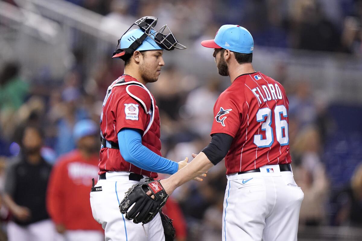 Miami Marlins catcher Alex Jackson, left, and relief pitcher Dylan Floro (36) shake hands after a baseball game against the Philadelphia Phillies, Saturday, Oct. 2, 2021, in Miami. Miami won 3-1. (AP Photo/Lynne Sladky)