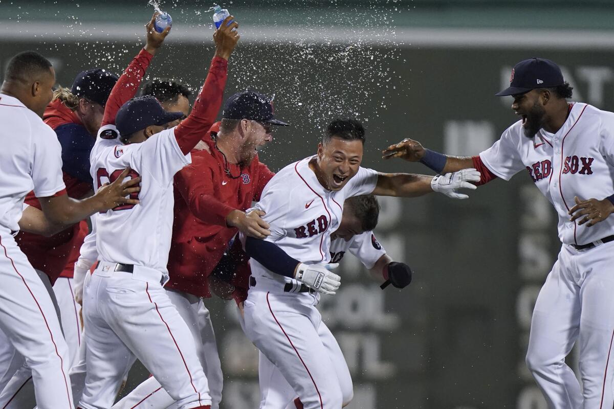 Boston Red Sox's Rob Refsnyder, center, celebrates with teammates after hitting a single to drive in the winning run in the ninth inning of the team's baseball game against the Texas Rangers, Thursday, Sept. 1, 2022, in Boston. (AP Photo/Steven Senne)