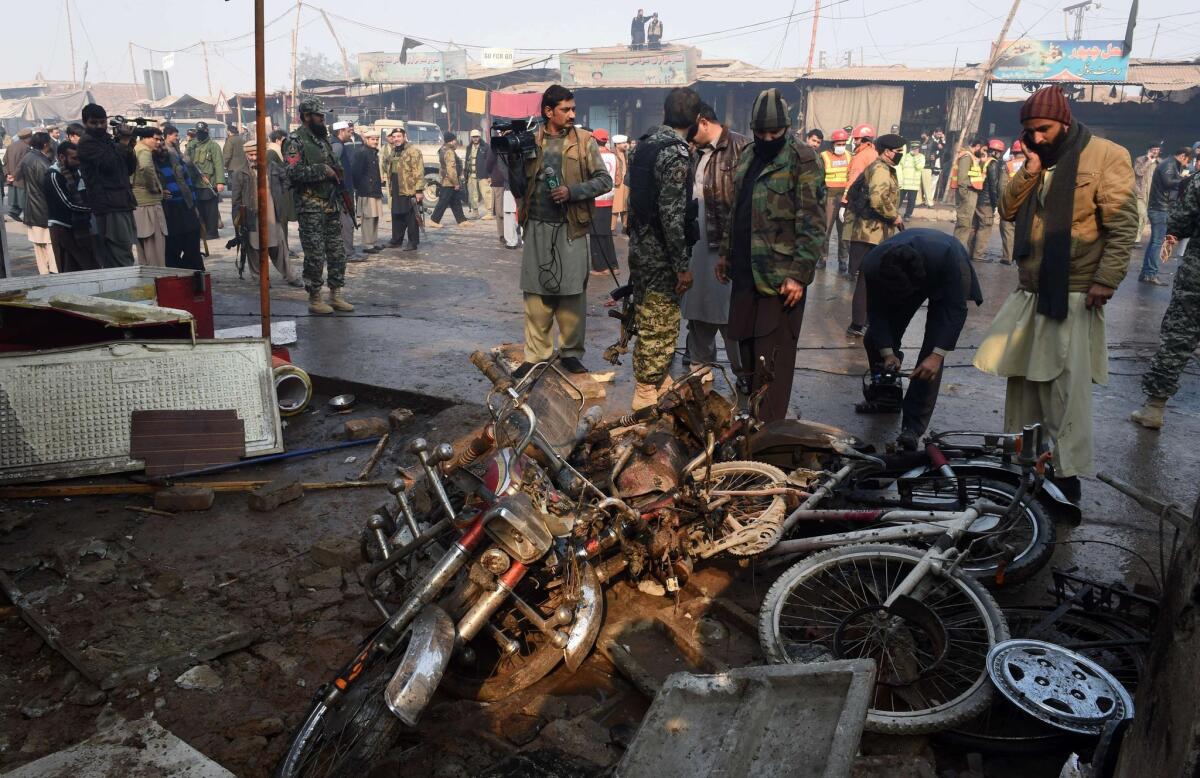 Pakistani security officials examine the site of a suicide bomb attack on the outskirts of Peshawar on Jan. 19.