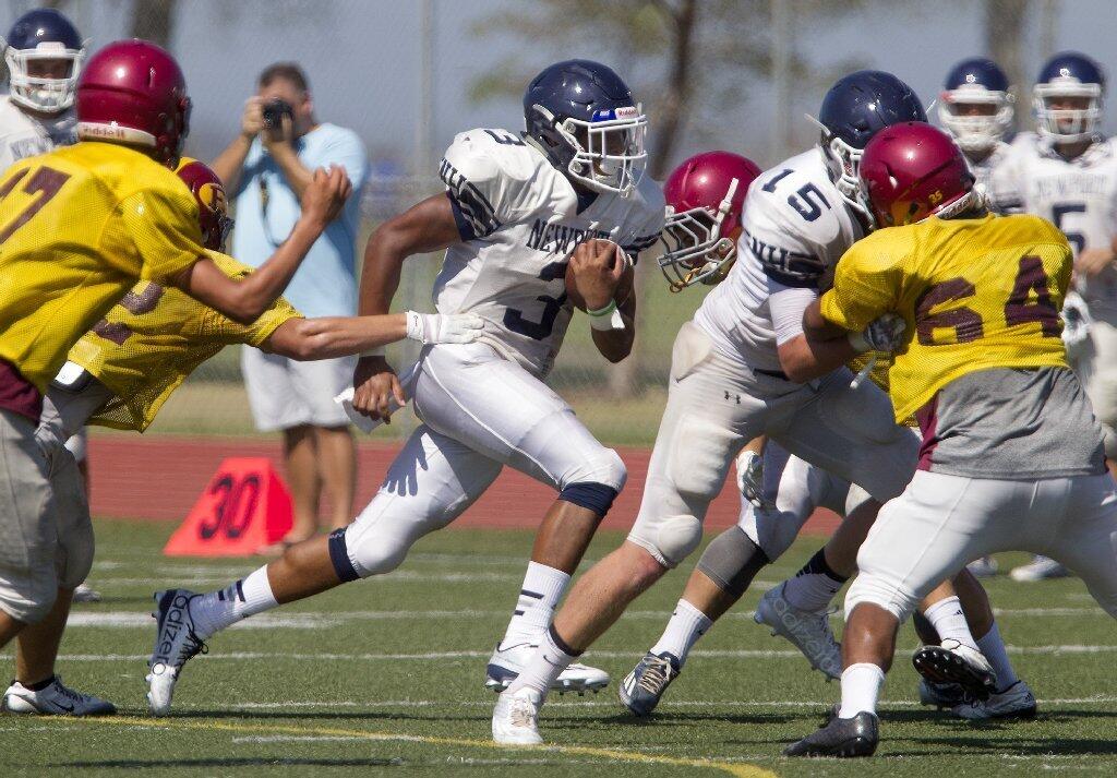 Newport Harbor High's Gage Roberson carries the ball during a scrimmage against Estancia at Jim Scott Stadium on Friday.