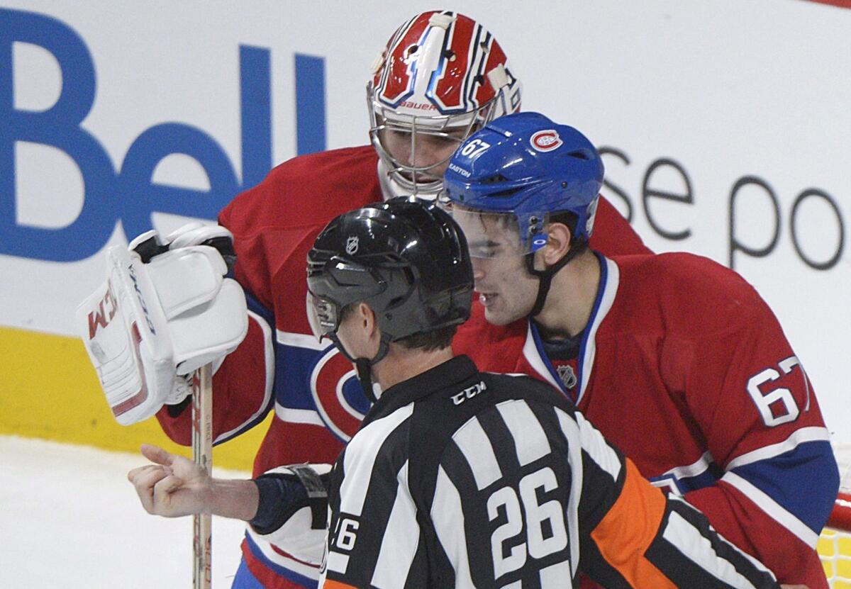 Montreal forward Max Pacioretty, with goaltender Carey Price looking on, shows his arm to a referee following a skirmish with Toronto's Mikhail Grabovski.