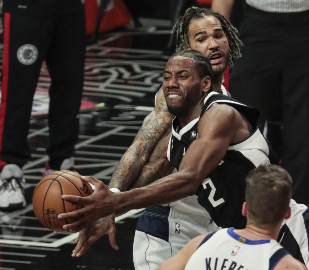 Dallas Mavericks forward Nicolas Batum slaps the arm of Clippers forward Kawhi Leonard.