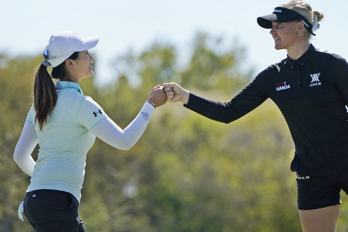 Xiyu Janet Lin, of China, left, fist bumps Charley Hull of England after playing the 18th hole during the LPGA The Ascendant golf tournament in The Colony, Texas, Saturday, Oct. 1, 2022. (AP Photo/LM Otero)