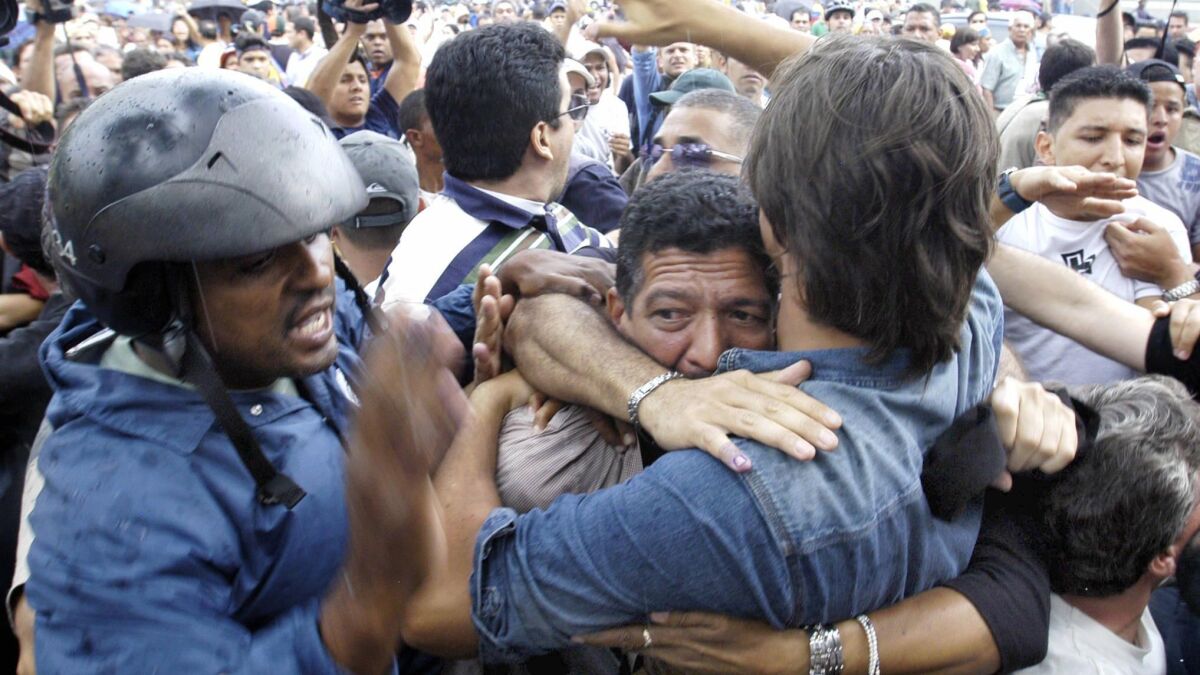 Civilians in Caracas, Venezuela give protection to a man who took part in a shooting that killed one and wounded four.