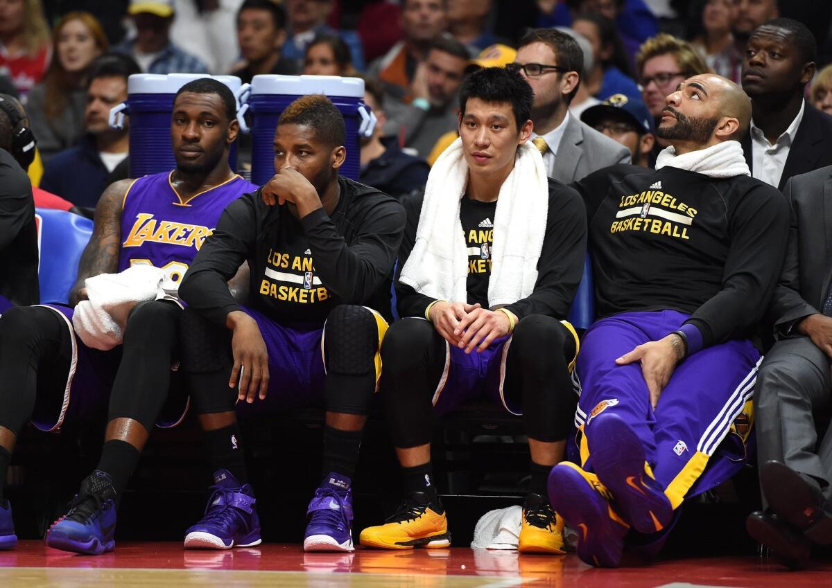 Tarik Black, left, Dwight Buycks, Jeremy Lin and Carlos Boozer sit on the Lakers bench during a 105-100 loss to the Clippers on April 7.
