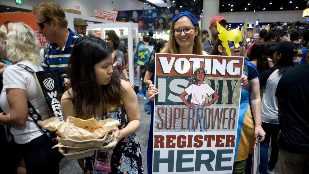 Rose Malinow carries a poster encouraging people to register to vote at Comic Con International in San Diego in July.