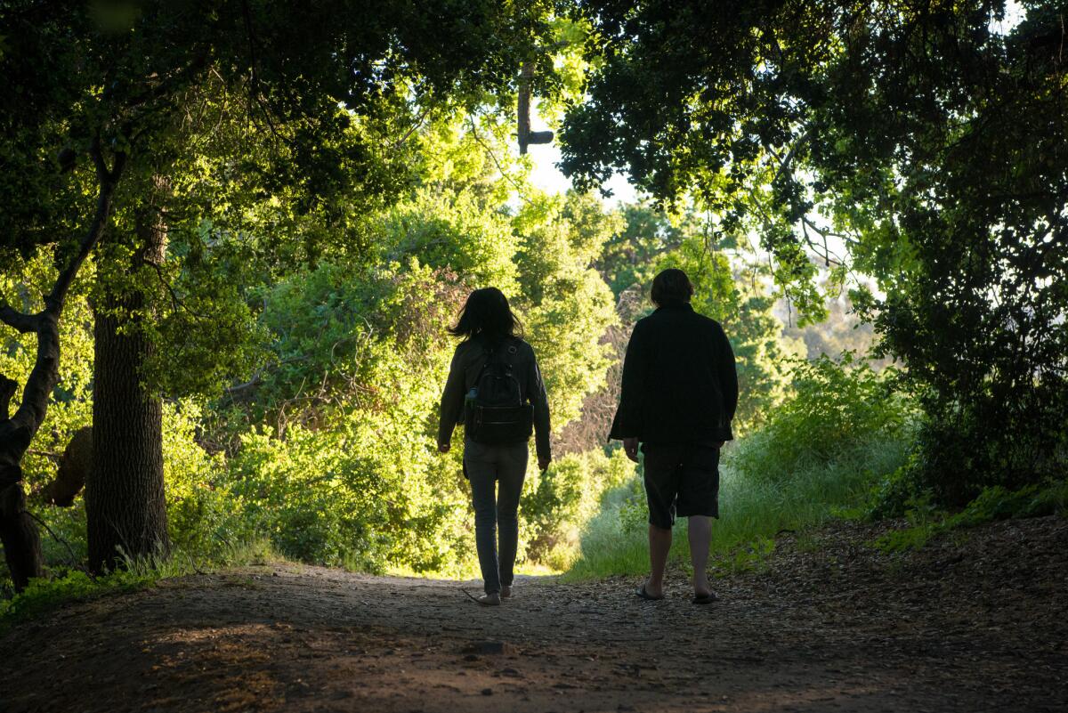 Yuan and Brandon Ryan, of Reseda, hike through an oak grove by a gully at Corriganville Park.