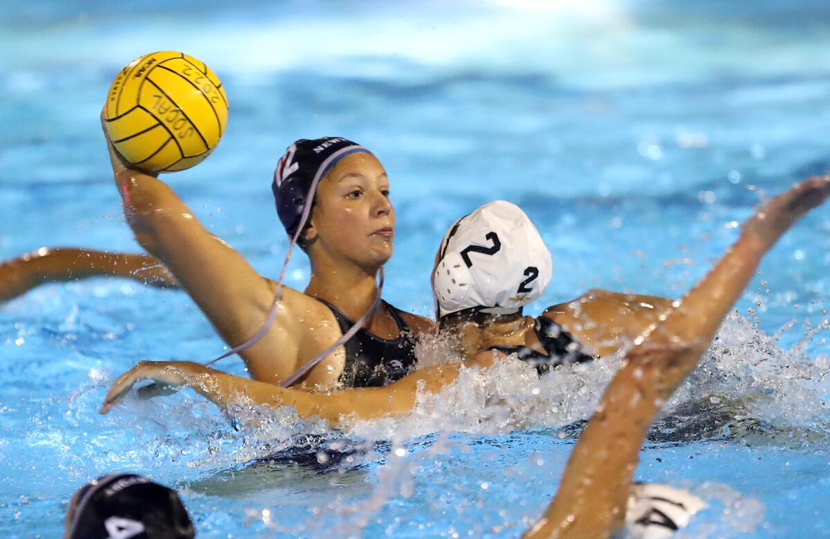 Newport Harbor's Bia Mantellato (12) holds off defender Grace Cuozzo as she fires in a goal.