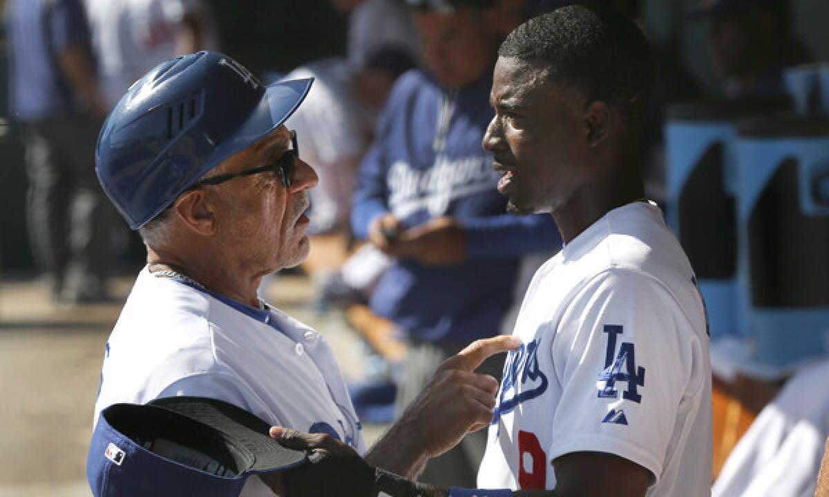 Dodgers first base coach and baserunning instructor Davey Lopes, left, speaks with infielder Dee Gordon during an exhibition game against the Texas Rangers on Friday. Gordon says he's practicing hard every day in order to make the Dodgers' opening day roster.