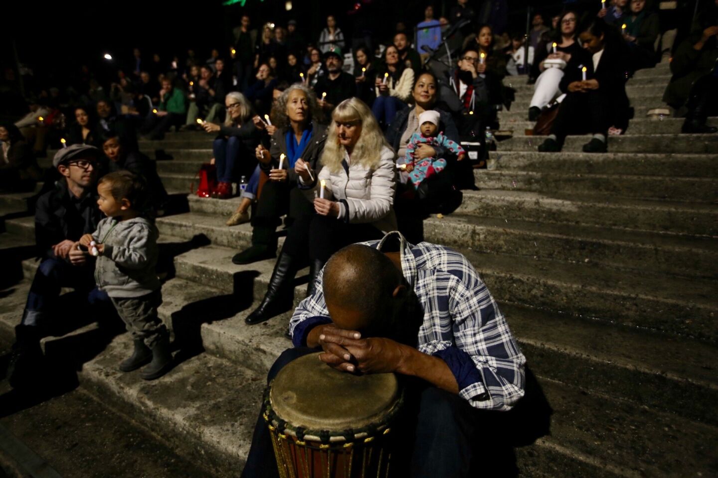 Mourners observe a moment of silence for the lives lost in the Ghost Ship warehouse fire at the Oakland Museum of California on Friday evening.