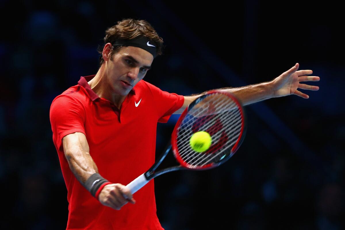 Roger Federer volleys a shot back to Stan Wawrinka in the semifinals of the ATP Finals tournament on Saturday in London.