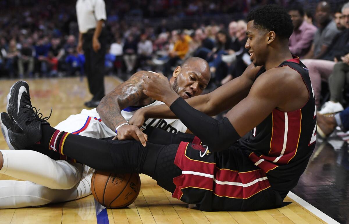Los Angeles Clippers center Marreese Speights, left, and Miami Heat center Hassan Whiteside battle for a loose ball during the Clippers' 98-98 win on Sunday.