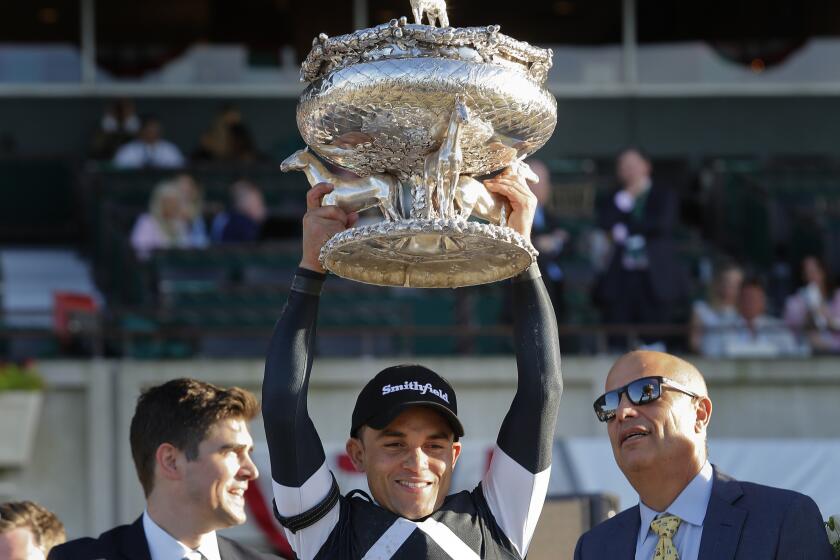 ARCHIVO - El jinete Joel Rosario, en el centro, sostiene el Trofeo Belmont de agosto después de ganar la 151ª carrera de caballos Belmont Stakes, el sábado 8 de junio de 2019, en Elmont, Nueva York. El ganador de la Triple Corona Justify, Caballo del Año 2017 Gun Runner y el jinete Joel Rosario han sido elegidos para el Museo Nacional de Carreras y el Salón de la Fama en su primer año de elegibilidad. (AP Foto/Eduardo Muñoz Álvarez, Archivo)