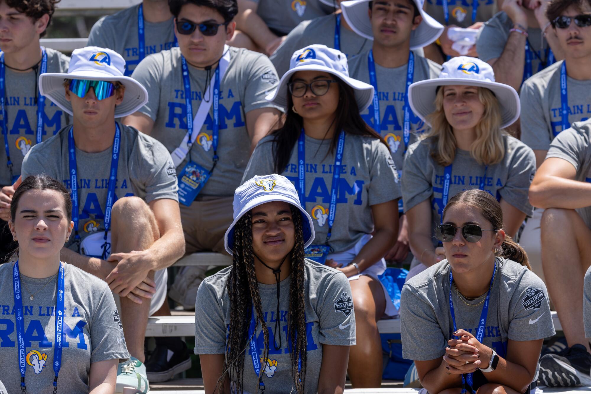 Rams interns sit in the bleachers awaiting instructions on the first day of training camp at Loyola Marymount. 