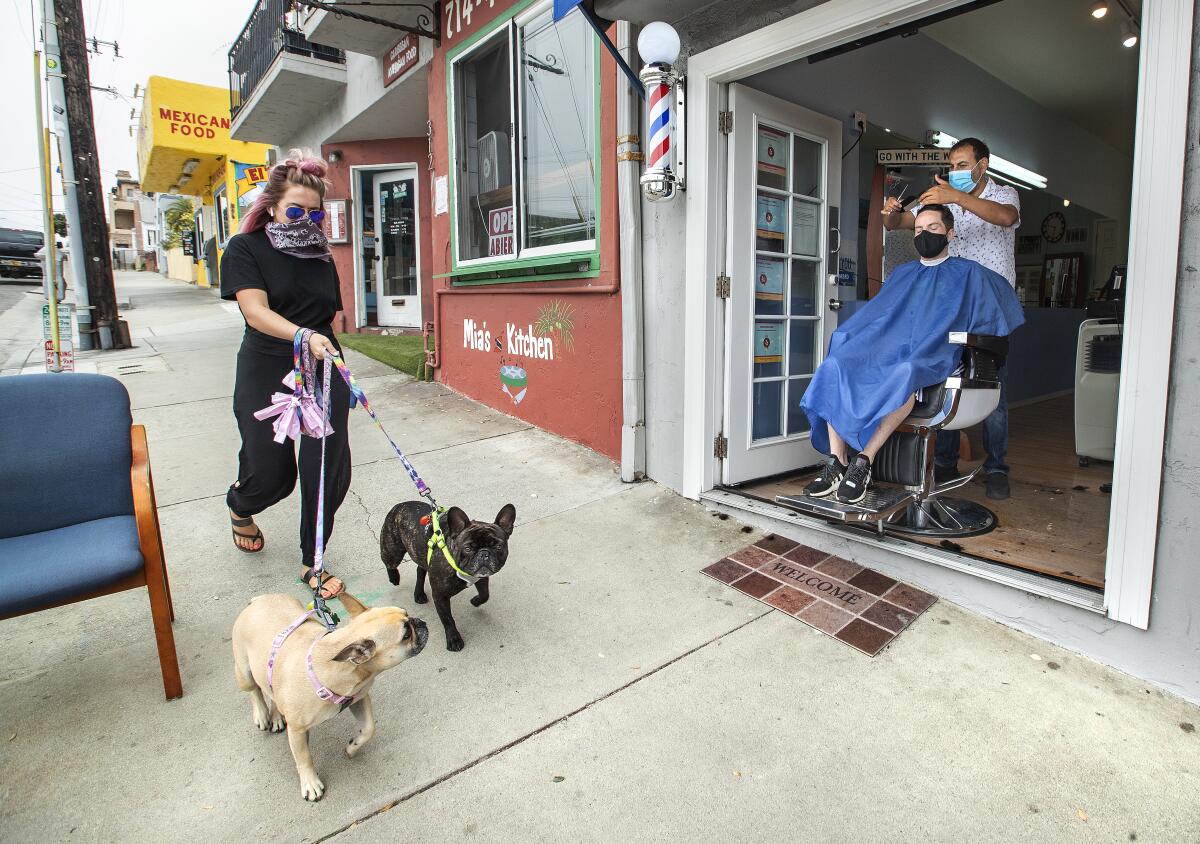 Faro Tabaja, owner of Waves Barbershop in Manhattan Beach, gives a haircut to Gene Geiser of Manhattan Beach.