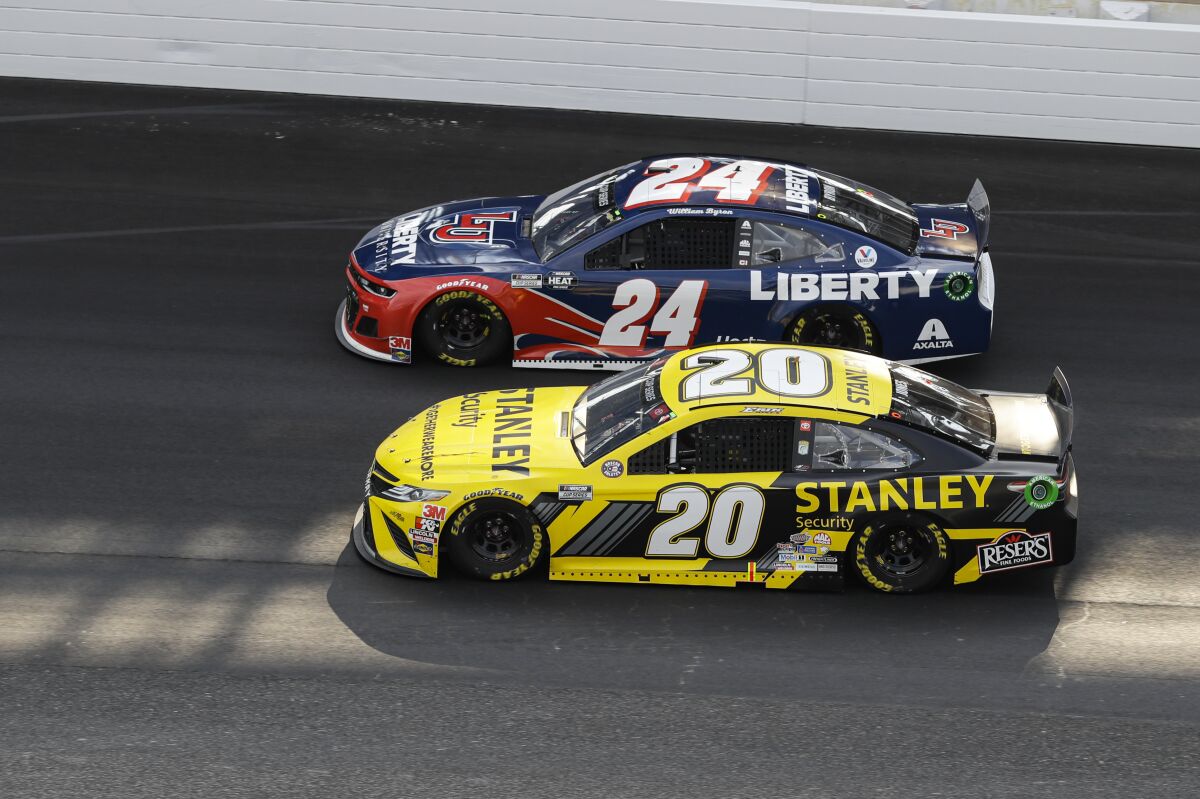 Erik Jones (20) and William Byron (24) head into the first turn during the NASCAR Cup Series auto race at Indianapolis Motor Speedway in Indianapolis, Sunday, July 5, 2020. (AP Photo/Darron Cummings)