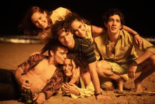 A group of friends embrace on a beach at night