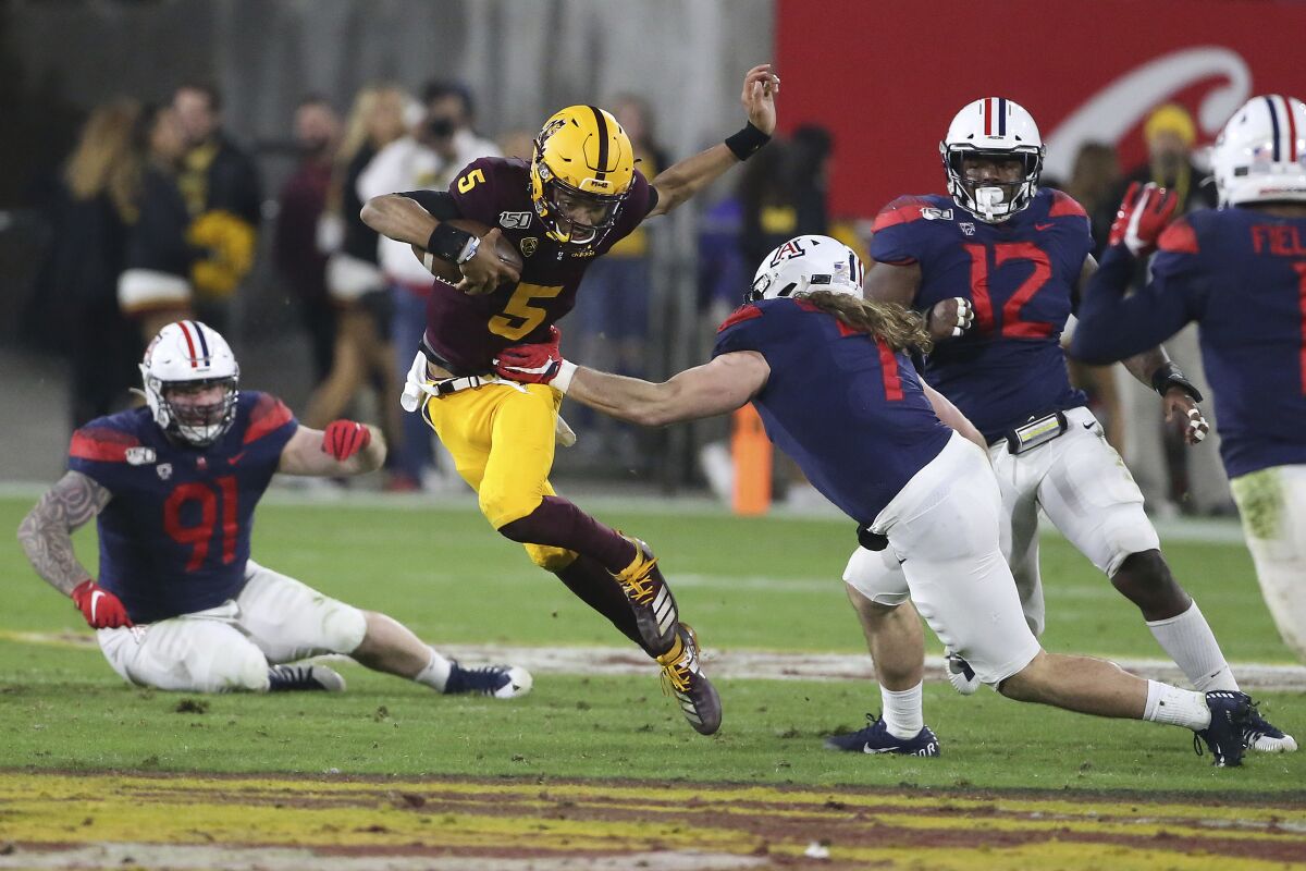 Arizona State's Jayden Daniels (5) runs against Arizona's defense