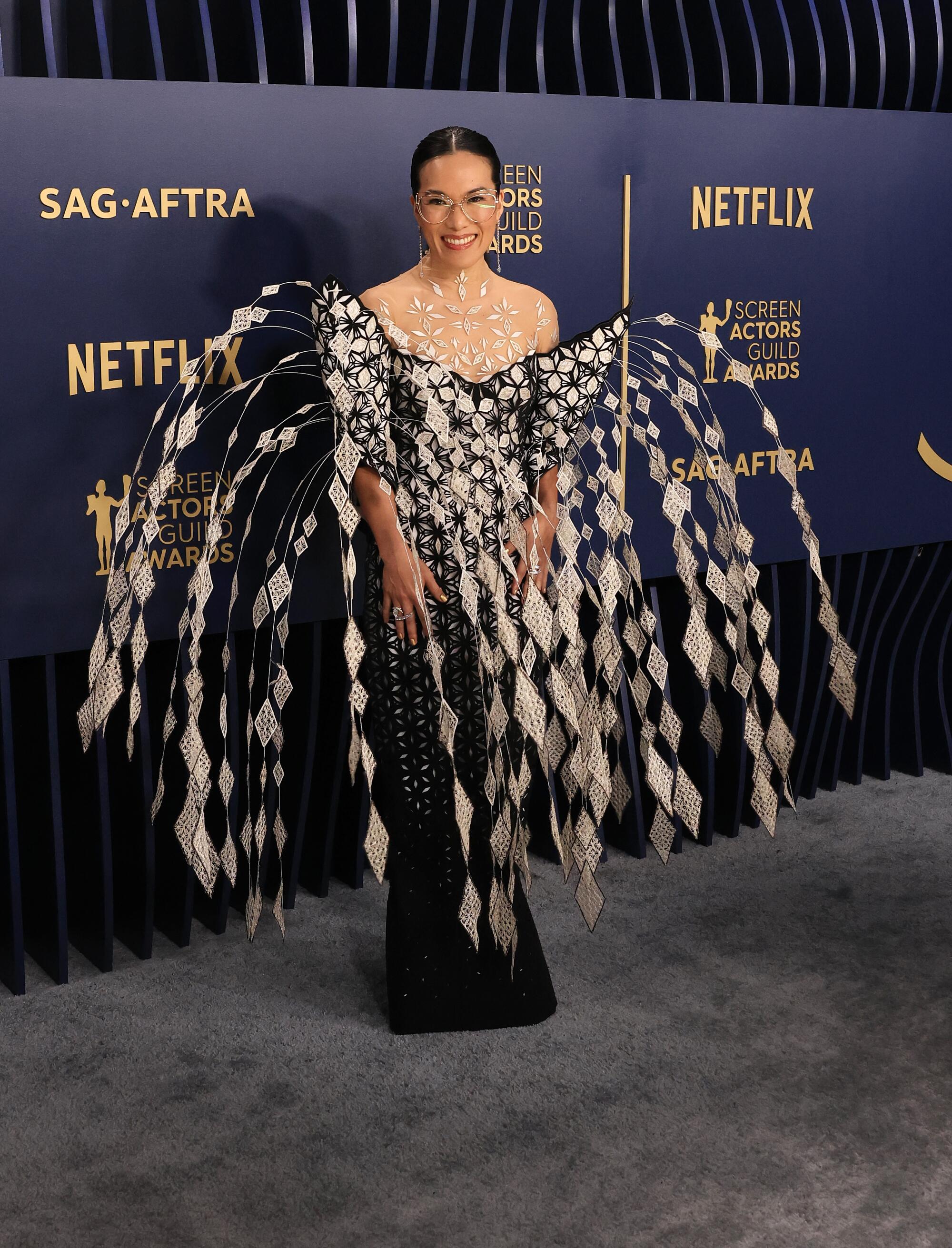 Ali Wong wears a black and white dress with a fountain of feathers at the SAG Awards. 