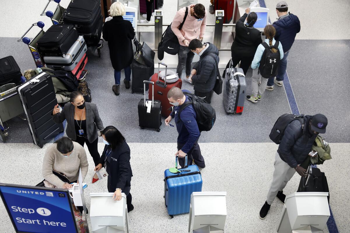  Travelers check in at United Airlines kiosks at LAX