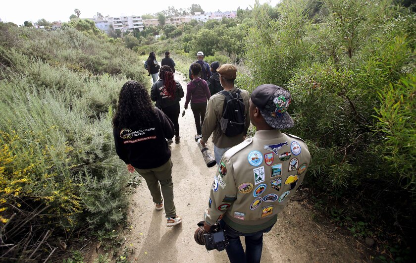 A group of people walking down a dirt path.