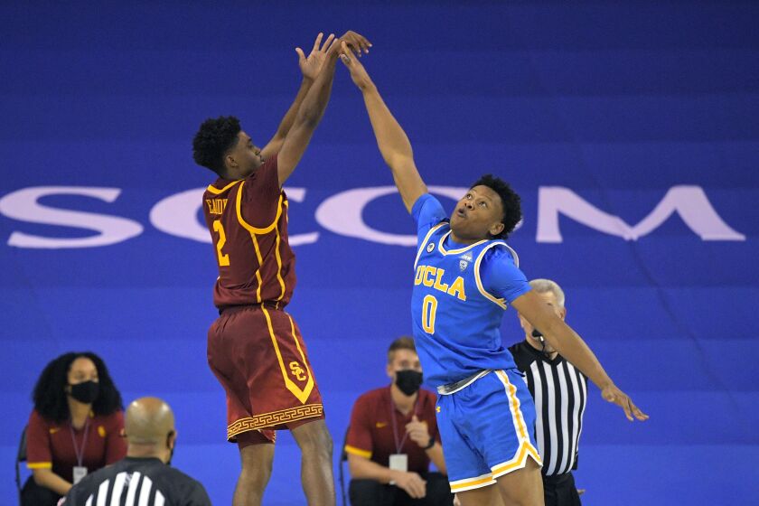 Southern California guard Tahj Eaddy, left, shoots and makes a game-winning three-point shot.