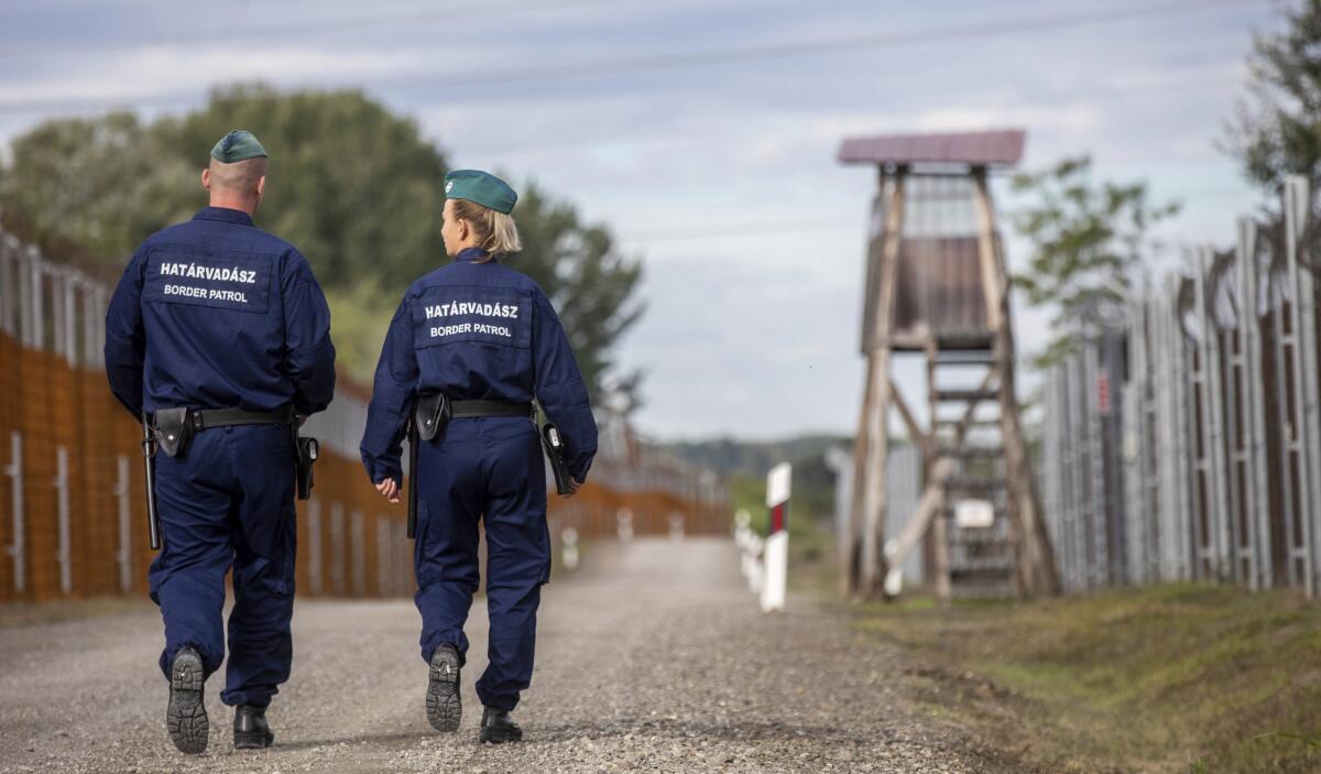 Border patrol officers walk along the service route of Hungary's border with Serbia near Roszke, Southern Hungary.