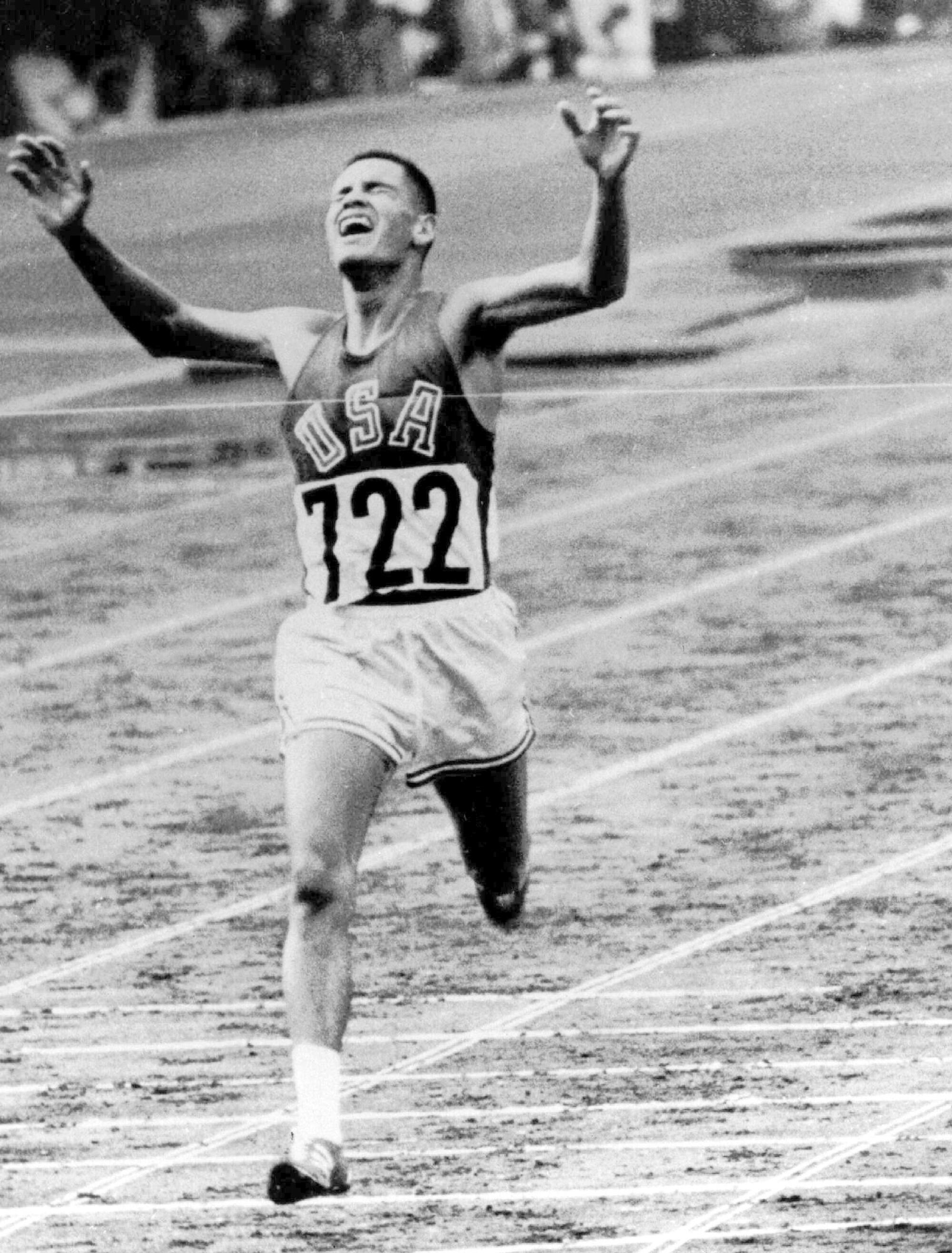 Billy Mills crosses the finish line to win the men's 10,000 meters at the 1964 Tokyo Olympics.