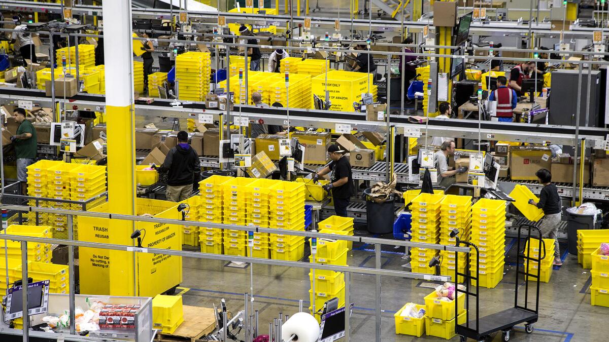 People stand around stacks of yellow rectangular containers.