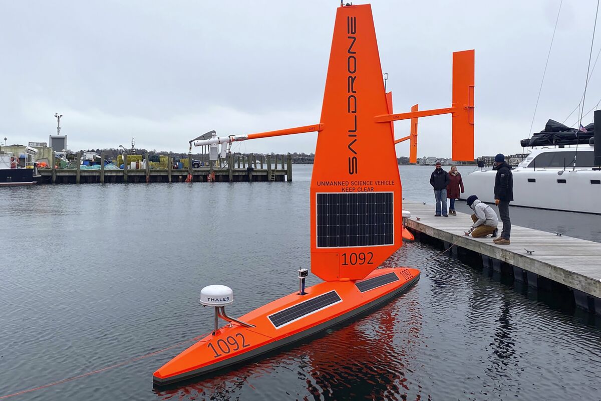 A Saildrone Explorer un-crewed surface vehicle, or ocean drone, is prepared for launch at a dock, in Newport, R.I., Wednesday, Dec. 8, 2021. Three of the drones are to be launched, Thursday, Dec. 9, 2021, and are expected to travel along the Gulf Stream, collecting data in tough winter conditions that would be challenging for traditional ships with crews. Saildrone, headquartered in Alameda, Calif., makes autonomous surface vehicles powered by the wind and sun to measure climate quality data and do mapping in remote oceans for scientists worldwide. (Susan Ryan/Saildrone via AP)