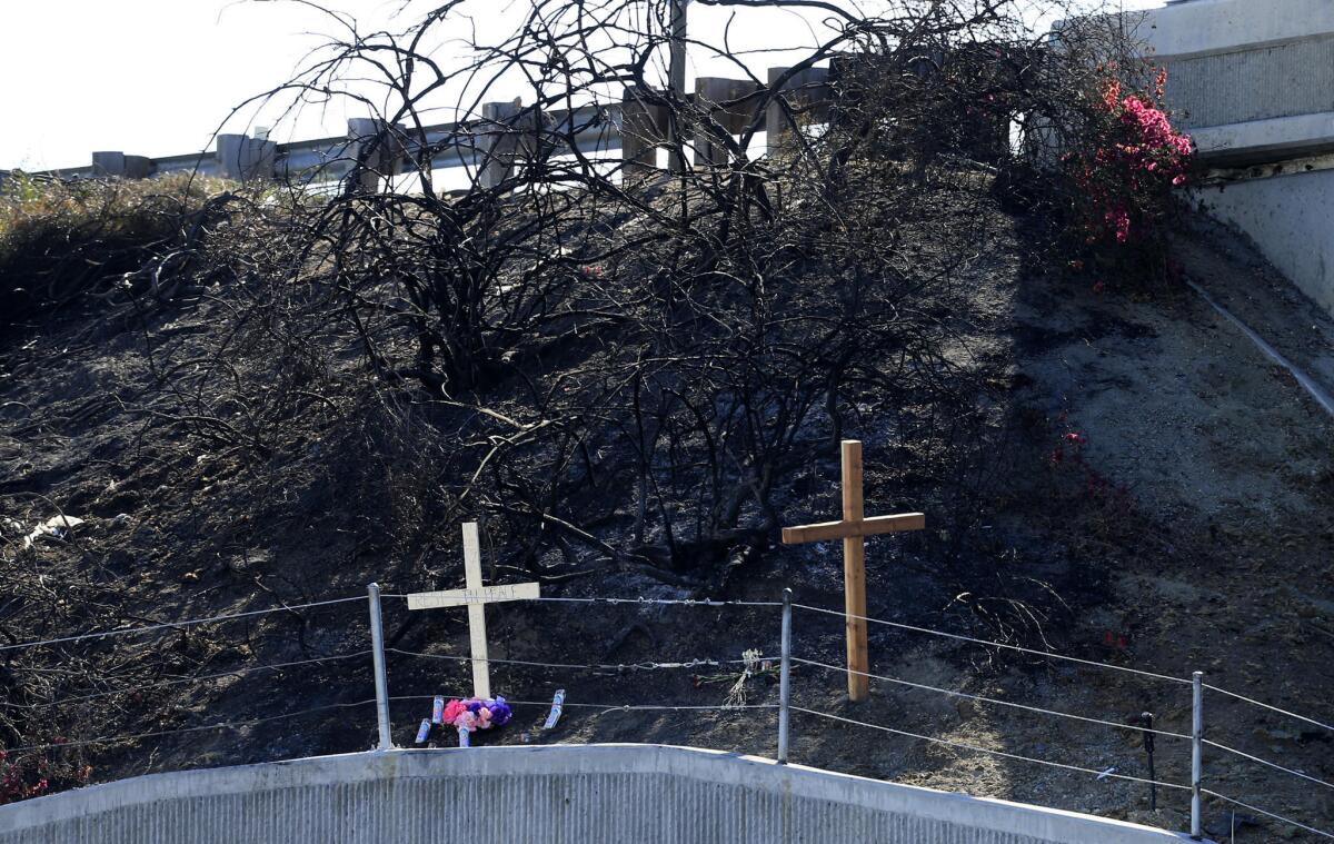 A makeshift memorial consisting of two wood crosses, candles and flowers marks the spot on a charred shoulder along southbound Interstate-5 in Irvine where five students from South Orange County died in a fiery crash October 4, 2014.