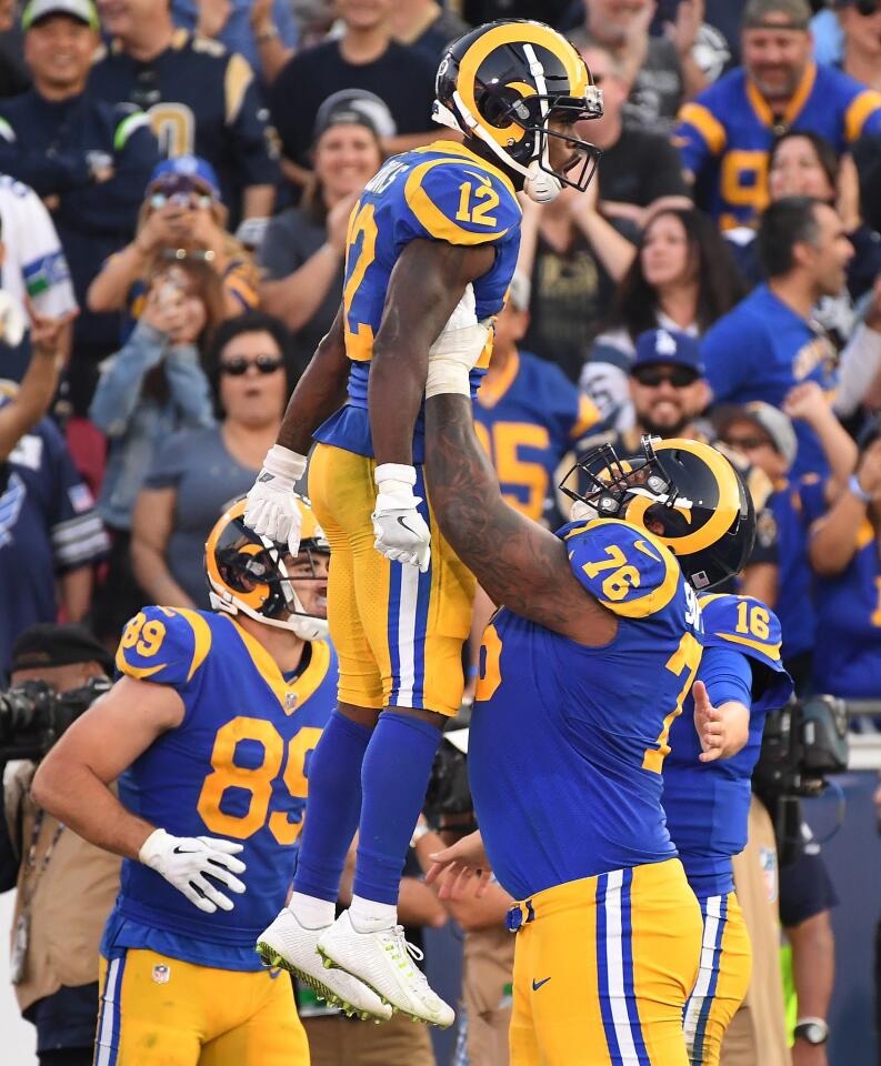 Rams receiver Brandin Cooks is lifted into the air by Rodger Saffold after scoring a touchdown against the Seahawks in the fourth quarter at the Coliseum on Sunday.