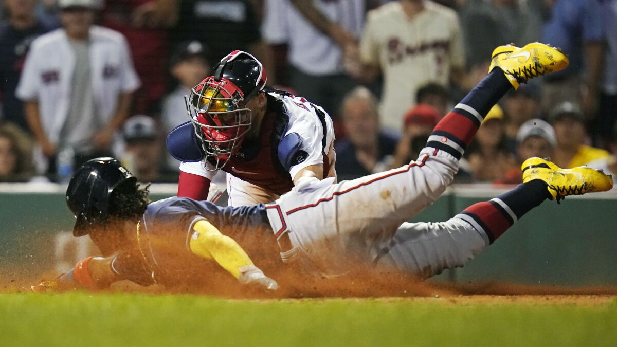 Atlanta Braves' Ronald Acuna Jr. beats the tag by Boston Red Sox catcher Kevin Plawecki to score on a two RBI single by Austin Riley during the 11th inning of a baseball game, Tuesday, Aug. 9, 2022, in Boston. (AP Photo/Charles Krupa)