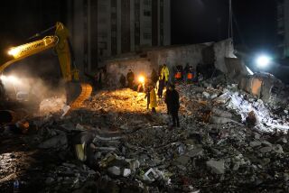 Equipos de emergencia buscan personas entre los escombros de un edificio destruido, el lunes 6 de febrero de 2022, en Adana, Turquía. (AP Foto/Khalil Hamra)