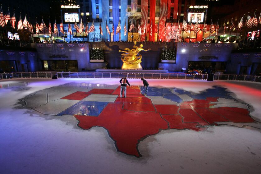 Workers change state colors in a gargantuan electoral map in the ice rink at Rockefeller Center