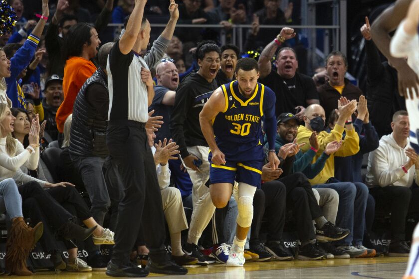 People react as Golden State Warriors guard Stephen Curry runs back upcourt after making a 3-point basket against the Minnesota Timberwolves during the second quarter of an NBA basketball game, Sunday, March 26, 2023, in San Francisco. (AP Photo/D. Ross Cameron)