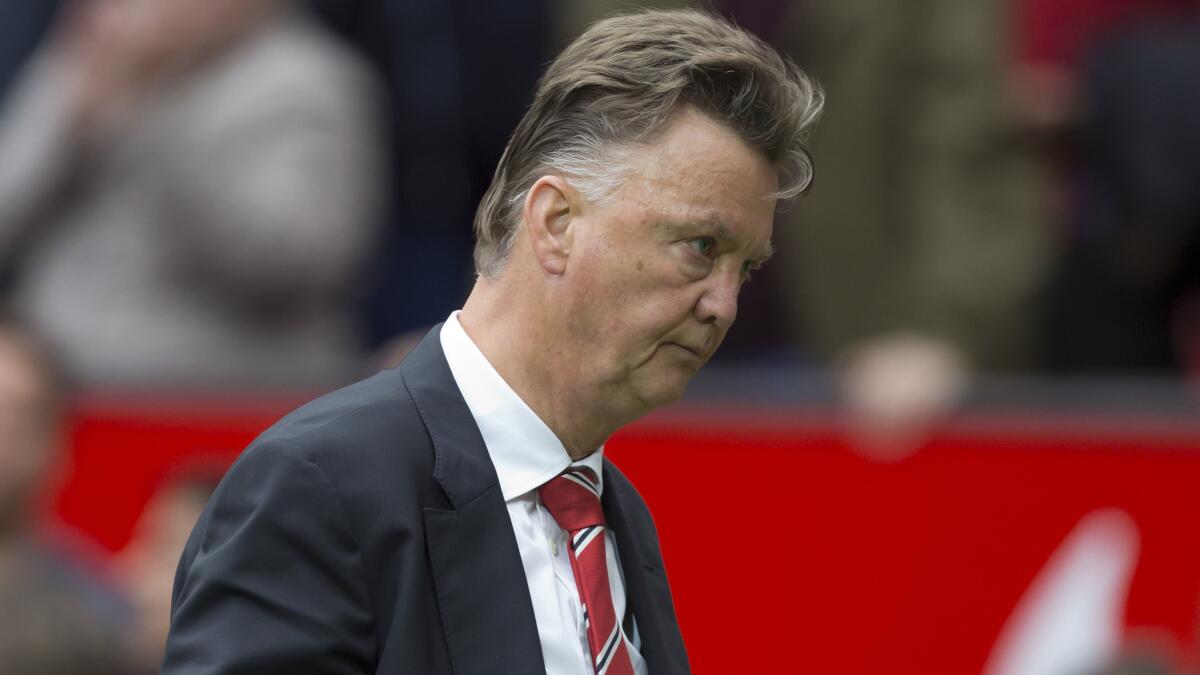 Manchester United Coach Louis van Gaal walks off the field following his team's 2-1 loss to Swansea City in their English Premier League opener Saturday.
